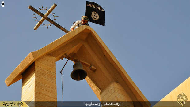 داعشى يقوم بإزالة الصلبان