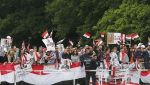Supporters of Egypt's President Sisi wave on his arrival in front of Bellevue presidential palace in Berlin