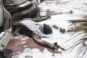 The body of a bomber is seen near damaged cars near a Shi'ite mosque in Saudi Arabia's Dammam